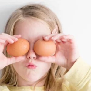 dziewczynka trzyma jaja kurze jak okulary